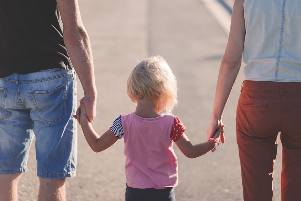 Home_IntuitiveEltern Mutter und Vater halten ihr Kind an den Händen